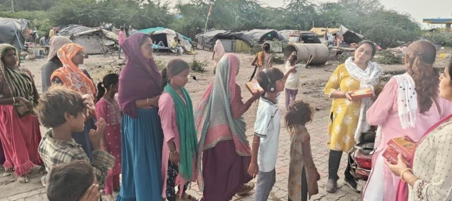 Distribution of sweet packets to labourer families