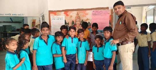 Students in blue uniforms presenting science models